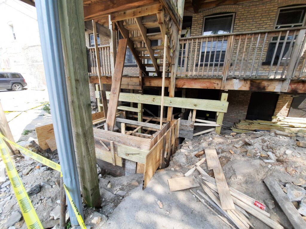 Construction site with unfinished wooden porch framework and scattered building materials.-Our Services