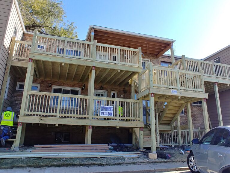 A new wooden porch construction on a brick building with multiple levels, featuring a banner with contact details
