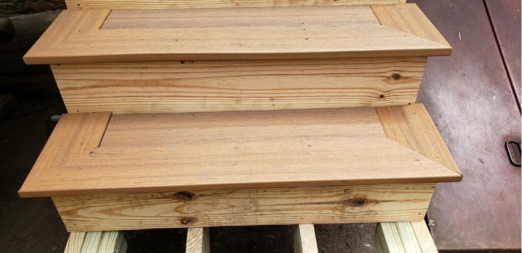 Close-up of wooden stairs with natural grain detailing and smooth finish on a construction site.