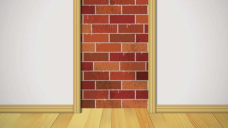 Brick wall segment framed by wooden trim inside a room.