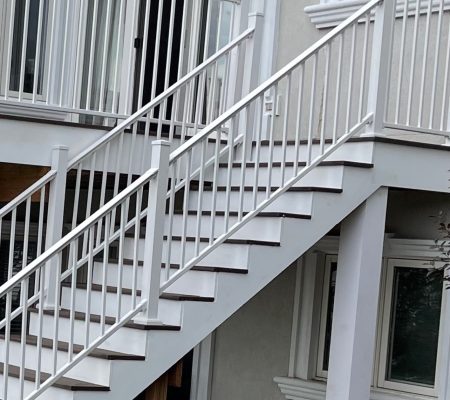 Guardrail White exterior staircase with metal railings leading up to a deck with matching white balustrades.